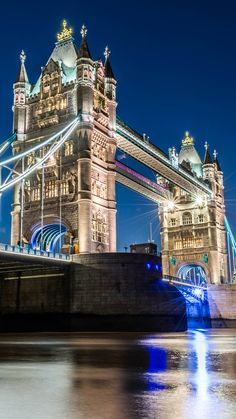 the tower bridge is lit up at night