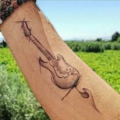 a man with a guitar tattoo on his arm