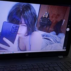 a laptop computer sitting on top of a desk with an image of a woman holding a cell phone