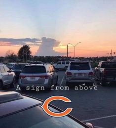 cars are parked in a parking lot with the sun setting behind them and an orange cloud