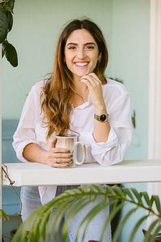 a woman holding a coffee cup and smiling