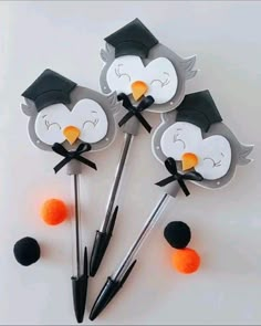 four penguins with graduation caps and tassels on their heads are arranged in the shape of balls