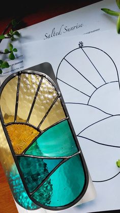 a stained glass sun catcher sitting on top of a table next to a planter