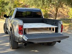 the truck is parked on the side of the road with it's bed open