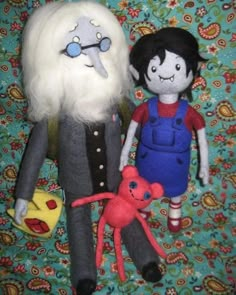 two dolls are posed next to each other