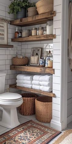 a white toilet sitting next to a wooden shelf filled with towels