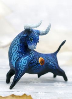 a small blue bull figurine sitting on top of a table