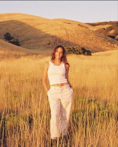 a woman standing in the middle of a field