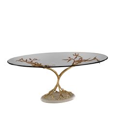 an oval glass table with gold branches on the top and bottom, against a white background