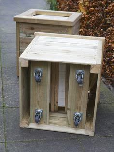 two wooden crates sitting next to each other on a sidewalk near some bushes and trees