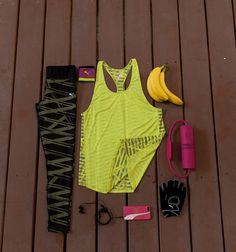 a woman's sports outfit and other items laid out on a wooden floor next to each other