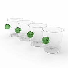 six glasses with green lids are lined up