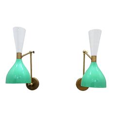 two green and white glass wall lights against a white background