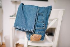 a pair of jeans sitting on top of a white chair