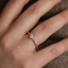 a woman's hand with a diamond ring on top of her finger and an engagement band