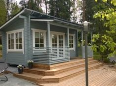 a small blue house sitting on top of a wooden deck