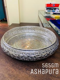 a silver bowl sitting on top of a wooden table