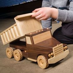 a child playing with a wooden toy truck