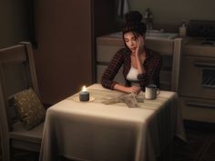 a woman sitting at a table with a candle in front of her