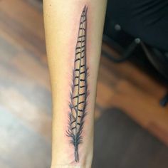 a black and white feather tattoo on the leg