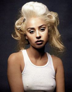 a woman with blonde hair wearing a white tank top