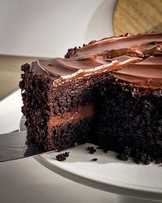 a piece of chocolate cake on a plate with a knife