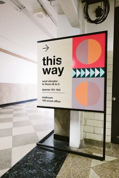 a sign that is on the side of a wall in an office building with black and white checkered flooring