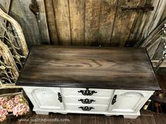 an old dresser is painted white and brown