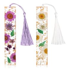 three bookmarks with flowers on them and tassels hanging from the top one