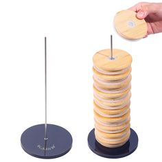 a stack of wooden discs being held by a person's hand over the top of them