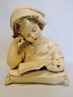 a ceramic figurine of a woman reading a book