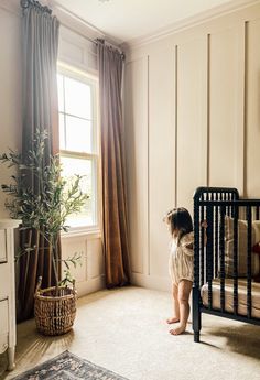 a baby standing in front of a crib with the words sweet baby girl nursery design