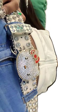 the belt is decorated with jewels and beads on it's side, while someone holds their phone in one hand