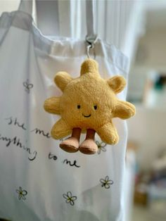 a yellow teddy bear hanging from a white bag