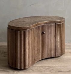 a wooden bench sitting on top of a hard wood floor next to a white wall