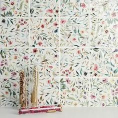 the wall is decorated with floral designs and has two toothbrushes next to it