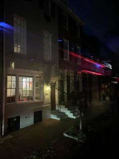 the building is lit up with red, white and blue lights on it's windows