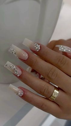 a woman's hand with some white and silver nail polishes on her nails