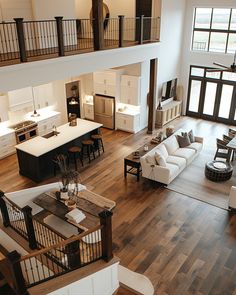 an overhead view of a living room and kitchen with hardwood floors, white furniture, and open floor plan