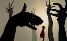 the shadow of a person standing in front of a wall with trees and a monster's head