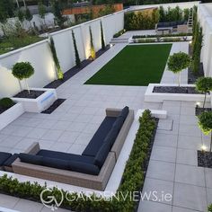 an aerial view of a modern garden with seating and trees in the background at night