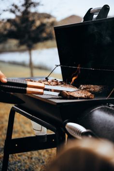 someone is grilling some meat on the grill