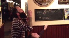 the man is reaching up to touch the chalkboard on the wall