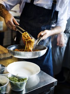 a chef is cooking spaghetti in a wok - stock photo - images