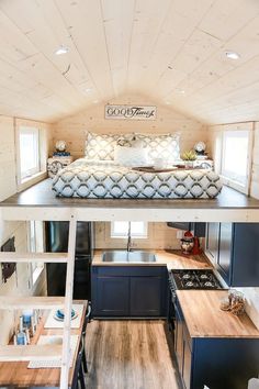 the interior of a tiny house with wood floors and walls, including a loft bed