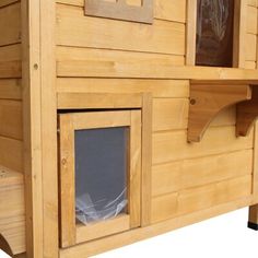 a dog house made out of wood with windows and doors on the outside, side by side