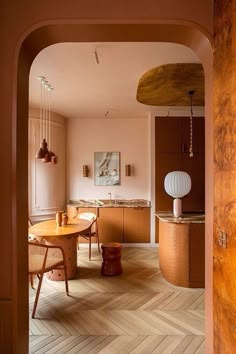 an archway leading to a kitchen and dining room with wood flooring on the walls