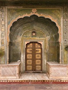 an ornate entrance to a building with two large wooden doors