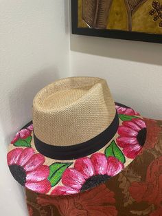 This hand-painted fedora is a unique summer hat, perfect as a floral sun hat for the beach, a garden party, or a summer wedding. This custom-painted fedora makes a one-of-a-kind gift for her, suitable for a birthday, Mother's Day, or any occasion, and is ideal as a summer fashion accessory for vacations and resort wear, making it a stylish tea party hat or beach accessory. Hand-Painted Floral Fedora: A Unique Summer Accessory Hand-painted floral design on a classic straw fedora, making each hat Pink Bohemian Fedora For Spring, Handmade Flower Hats For Summer, Spring Multicolor Brimmed Panama Hat, Multicolor Brimmed Panama Hat For Spring, Summer Multicolor Flower Hat, Summer Multicolor Flower-shaped Hat, Multicolor Flower-shaped Summer Hat, Summer Flower-shaped Multicolor Hat, Pink Floral Print Hat For Summer