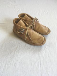 vintage 1970s women's moccasin shoes Taos light brown leather rubber sole cushion sole tie front concho  good vintage condition, light wear, insole cushion fiber has some shedding marked size 6 1/2 measures, insole-9 1/4" sole-9 1/2" width-3 1/8" Brown Leather-sole Moccasins With Round Toe, Brown Leather Sole Round Toe Moccasins, Brown Round Toe Moccasins With Leather Sole, Leather Sole Lace-up Moccasins For Fall, Lace-up Leather Sole Moccasins For Fall, Bohemian Leather Moccasins For Fall, Brown Low-top Moccasins With Leather Footbed, Lace-up Moccasins With Leather Sole For Fall, Fall Lace-up Moccasins With Rubber Sole